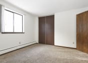 Thumbnail 22 of 32 - an empty room with white walls and a wooden door and a window. Maplewood, MN Maplewood Apartments