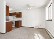 Thumbnail 19 of 32 - an empty living room with a ceiling fan and a kitchen. Maplewood, MN Maplewood Apartments