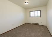 Thumbnail 13 of 20 - a bedroom with carpet and a window. Fargo, ND Maplewood Bend Apartments