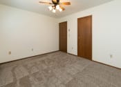 Thumbnail 14 of 20 - a bedroom with carpet and a ceiling fan. Fargo, ND Maplewood Bend Apartments
