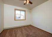 Thumbnail 14 of 17 - a bedroom with carpet and a window. Fargo, ND Maybrook Apartments