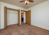 Thumbnail 13 of 17 - a bedroom with a ceiling fan and a closet. Fargo, ND Maybrook Apartments