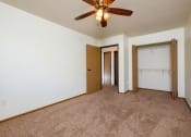 Thumbnail 11 of 17 - a bedroom with carpet and a ceiling fan. Fargo, ND Maybrook Apartments