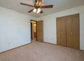 Thumbnail 8 of 17 - a bedroom with a ceiling fan and a closet. Fargo, ND Maybrook Apartments