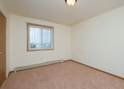 Thumbnail 9 of 17 - a bedroom with carpet and a window. Fargo, ND Maybrook Apartments