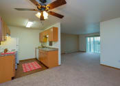 Thumbnail 6 of 17 - an empty kitchen and living room with a ceiling fan. Fargo, ND Maybrook Apartments