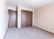 Thumbnail 10 of 16 - Grand Forks, ND Mayfair Apartments a bedroom with two doors and a carpeted floor