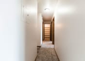 Thumbnail 12 of 16 - Grand Forks, ND Mayfair Apartments a corridor with white walls and a carpeted floor