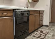 Thumbnail 8 of 16 - Grand Forks, ND Mayfair Apartments a kitchen with wooden cabinets and a black dishwasher