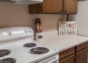 Thumbnail 7 of 16 - Grand Forks, ND Mayfair Apartments a kitchen with a stove and cabinets