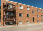 Thumbnail 16 of 16 - Grand Forks, ND Mayfair Apartments a brick building with two balconies and a street in front of it
