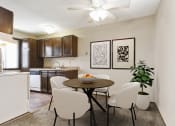 Thumbnail 3 of 32 - Georgetown on the River Apartments, Fridley, MN. a dining area with a table and chairs and a kitchen in the background