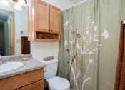 Thumbnail 25 of 26 - a bathroom with a shower curtain and a sink and a toilet. Fargo, ND Monticello Apartments