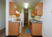 Thumbnail 22 of 26 - a kitchen with white appliances and wooden cabinets. Fargo, ND Monticello Apartments