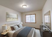 Thumbnail 3 of 16 - a bedroom with a bed and a dresser and a window. Moorhead, MN South Park Apartments