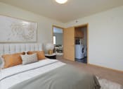 Thumbnail 3 of 18 - a bedroom with a bed and a washer and dryer in a room. Moorhead, MN Sandy Creek Apartments