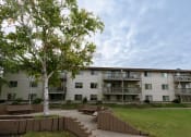Thumbnail 16 of 16 - an apartment building with a lawn and a tree in front of it. Moorhead, MN South Park Apartments