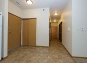 Thumbnail 12 of 23 - a hallway with white walls and wooden doors and a carpeted floor. Fargo, ND North Sky Apartments