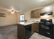 Thumbnail 7 of 10 - a kitchen with black appliances and a granite counter top. Bismarck, ND Newgate Apartments