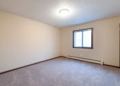Thumbnail 8 of 10 - a bedroom with carpet and a window. Bismarck, ND Newgate Apartments
