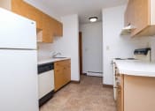 Thumbnail 7 of 16 - an empty kitchen with a refrigerator and a sink. Fargo, ND North Manor Apartments