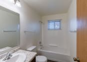 Thumbnail 15 of 16 - a bathroom with a sink toilet and bath tub and a mirror. Fargo, ND North Manor Apartments