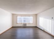 Thumbnail 9 of 16 - an empty living room with a large window and wood floors. Fargo, ND North Manor Apartments