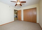 Thumbnail 6 of 21 - a bedroom with a closet and ceiling fan. Fargo, ND Crossroads Apartments