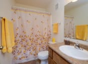 Thumbnail 10 of 11 - Bathroom with a sink and a toilet and a shower at Oak Court Apartments, ND