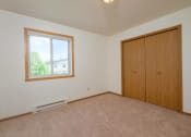 Thumbnail 8 of 11 - Empty bedroom with a window and a closet. Fargo, ND 58013 Oak Court Apartments