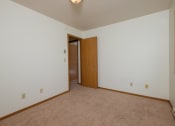 Thumbnail 9 of 11 - Bedroom with white walls and a door to a closet. Oak Court Apartments, Fargo