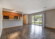Thumbnail 8 of 21 - Omaha, NE Beacon Hill Apartments. An empty living room with a sliding glass door leading to a patio
