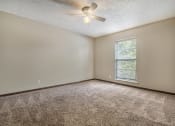 Thumbnail 15 of 21 - Omaha, NE Beacon Hill Apartments. An empty room with a ceiling fan and a window