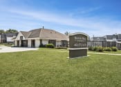 Thumbnail 1 of 21 - an exterior of an apartment office with a sign and green grass out front. Omaha, NE Beacon Hill Apartments.