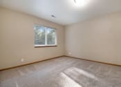 Thumbnail 7 of 10 - Omaha, NE Deerfield Apartments. An empty bedroom with a large window and beige walls