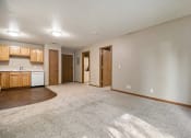 Thumbnail 6 of 10 - Omaha, NE Deerfield Apartments. A spacious living room with a kitchen in the background