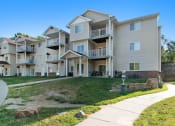 Thumbnail 10 of 10 - Omaha, NE Deerfield Apartments. An exterior view of an apartment complex with a sidewalk in front of it