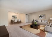 Thumbnail 6 of 34 - Omaha, NE Evergreen Terrace Apartments. A living room with a couch a table and a chair