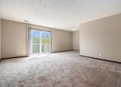 Thumbnail 17 of 23 - Omaha, NE Maple Ridge Apartments. A living room with a sliding glass door leading to a balcony