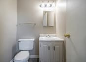 Thumbnail 10 of 23 - Omaha, NE Maple Ridge Apartments. A bathroom with a toilet sink and mirror