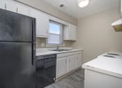 Thumbnail 7 of 23 - Omaha, NE Maple Ridge Apartments. A kitchen with white cabinets and black appliances
