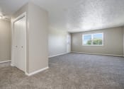 Thumbnail 8 of 23 - Omaha, NE Maple Ridge Apartment. A bedroom with carpet and a door to a bathroom