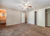 Thumbnail 14 of 23 - Omaha, NE Maple Ridge Apartments. A bedroom with carpeted floors and a ceiling fan