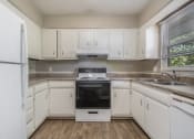Thumbnail 12 of 23 - Omaha, NE Maple Ridge Apartments. A kitchen with white cabinets and white appliances