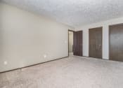 Thumbnail 10 of 29 - Omaha, NE Stony Brook Townhomes. A bedroom with two doors and a carpeted floor