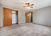 Thumbnail 12 of 27 - Omaha, NE Woodland Pines Apartments. A bedroom with a ceiling fan and two doors