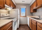 Thumbnail 10 of 27 - Omaha, NE Woodland Pines Apartments. A kitchen with white appliances and wooden cabinets