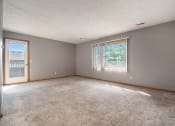 Thumbnail 8 of 27 - Omaha, NE Woodland Pines Apartments. A living room with a door and a large window