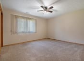 Thumbnail 25 of 27 - a bedroom with a ceiling fan and a window. Omaha, NE Woodland Pines Apartments