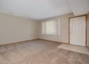 Thumbnail 22 of 27 - an empty living room with an exterior door. Omaha, NE Woodland Pines Apartments